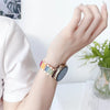 Nahaufnahme einer Hand mit einem verstellbaren Harz-Metallarmband mit mehrfarbigen Segmenten und silberfarbener Armband.