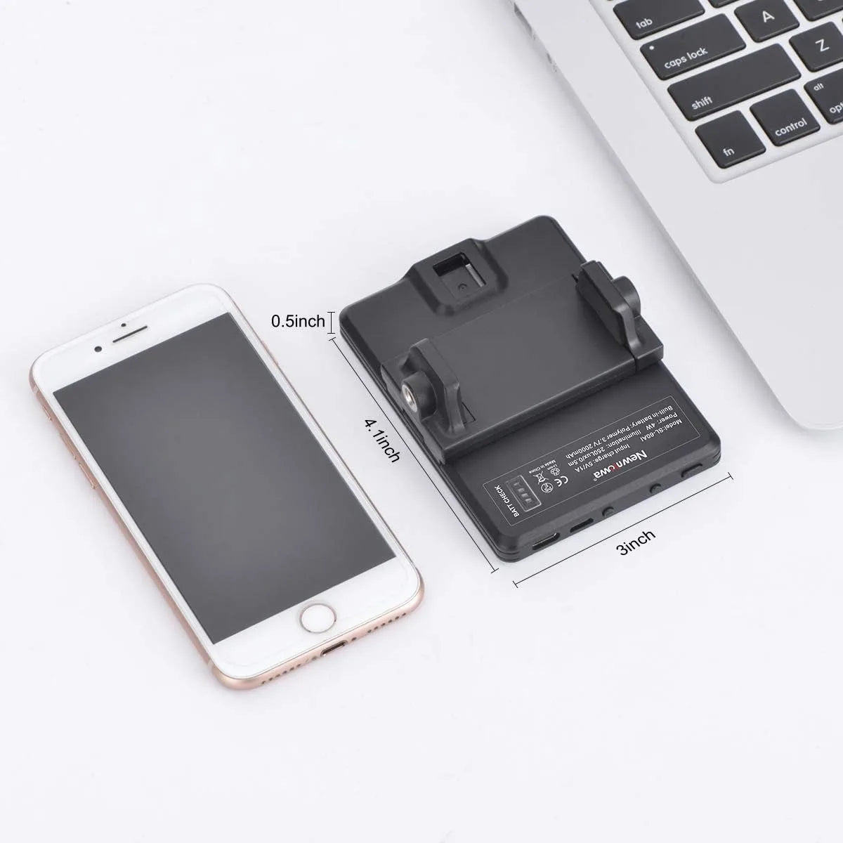 A portable clip-on LED selfie light is shown next to a smartphone and a laptop keyboard.