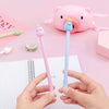 A pair of pink and blue cute cartoon fruit gel pens are held over a white notepad.