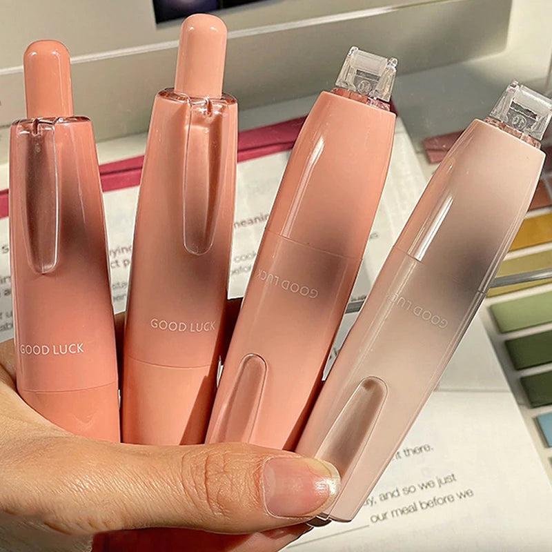 Una mano sostiene un set de tubos cosméticos rosados etiquetados como Buena Suerte para cinta adhesiva de doble cara de uso r