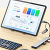 A tablet displaying a digital interface showing various connected devices and financial data, next to a keyboard and USB hub 