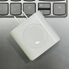 Chargeur multi-ports blanc 3-en-1 posé sur un clavier d'ordinateur portable gris.