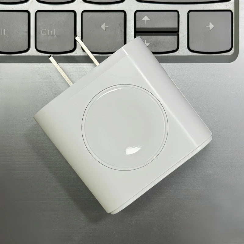 Chargeur multi-ports blanc 3-en-1 posé sur un clavier d'ordinateur portable gris.