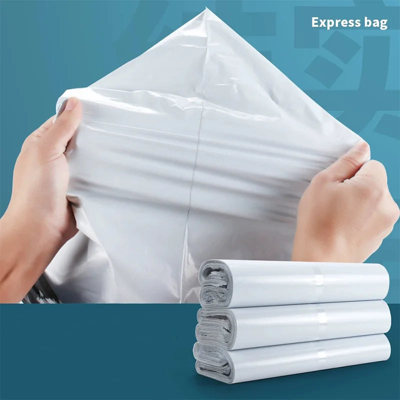 A hand is holding a white self-adhesive courier mailer bag, with several rolled bags stacked below it.