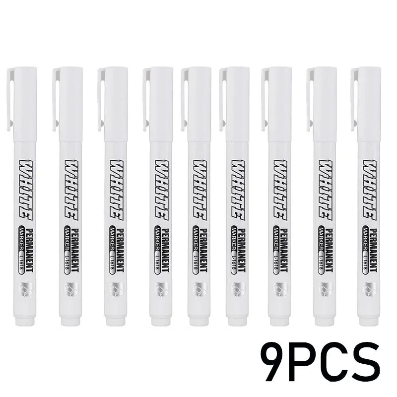 Nine white permanent metal paint markers displayed in a row.