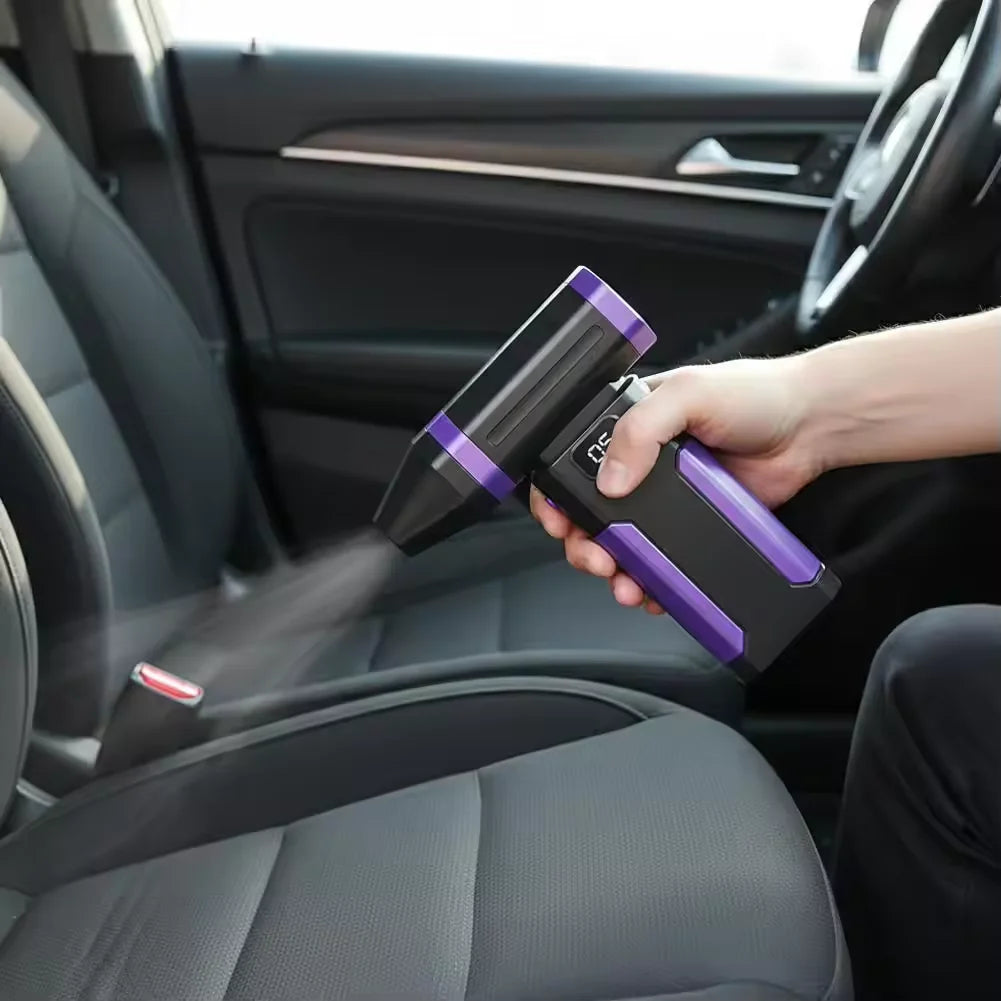 A hand is using a purple high-speed cordless air blower to clean the interior of a car seat.
