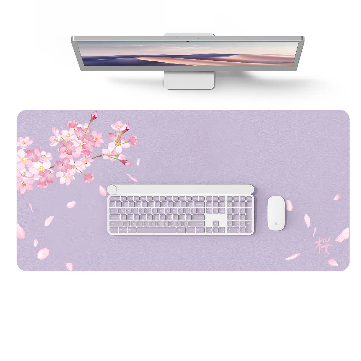 A silver laptop is displayed above a large purple desk mat featuring pink blossoms and a white keyboard and mouse.