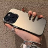 A hand holds a silver phone case with multiple camera lenses and a watch, set against a textured wall.