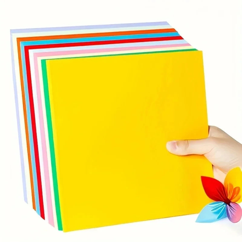 A stack of colorful cardstock sheets in various stripes and a bright yellow sheet being held by a hand.