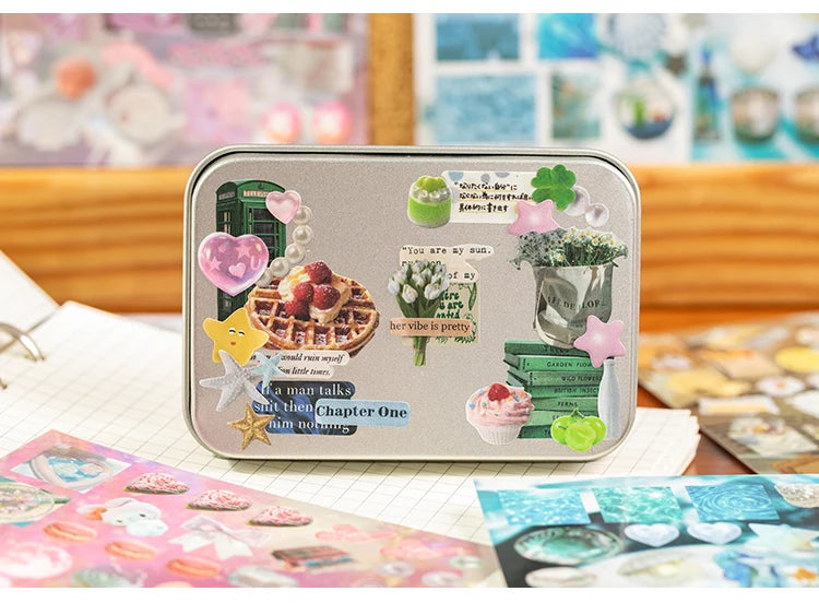 A silver metal case featuring various Y2K aesthetic cut film stickers on the lid.