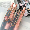 A set of six butterfly design gel pens in various shades of pink and black are displayed on a white surface.