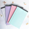 A collection of colorful tearable lined writing pads in pink, purple, and light blue are arranged on a white surface.