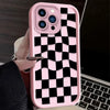 A pink silicone phone case with a black and white checkered pattern is shown next to a laptop.