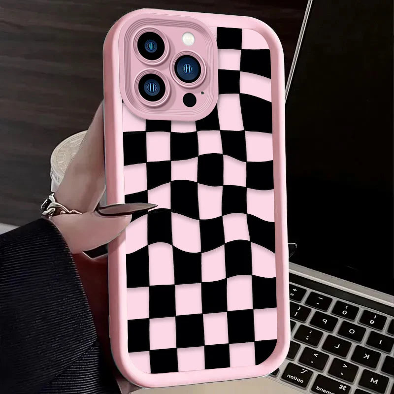 A pink silicone phone case with a black and white checkered pattern is shown next to a laptop.