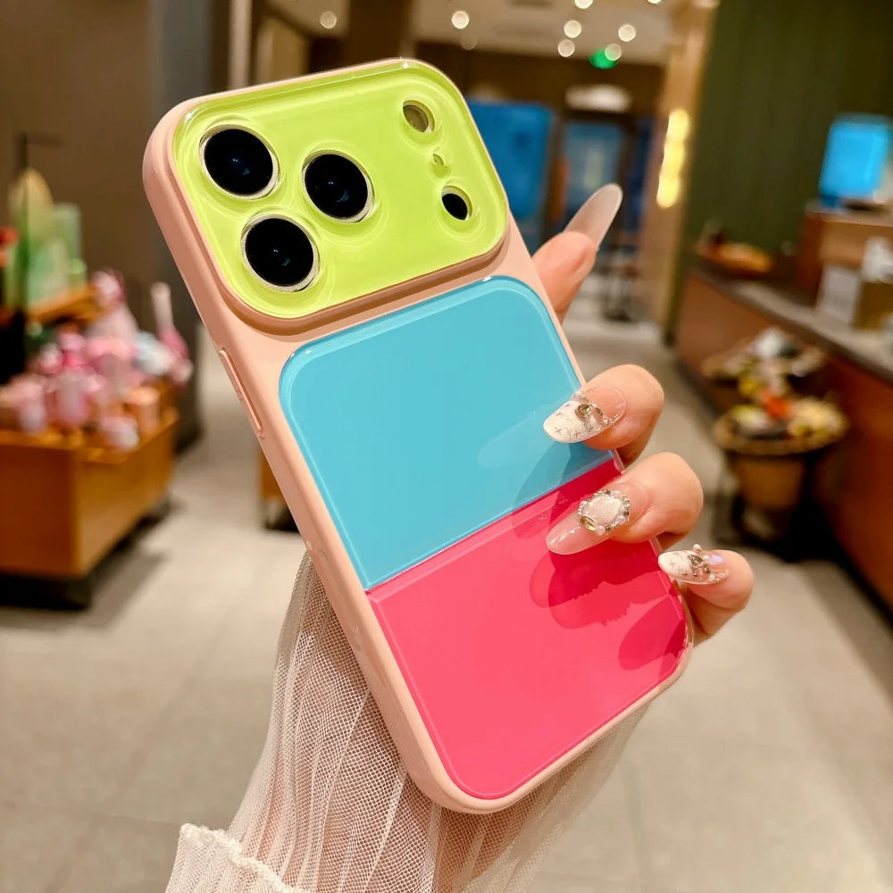 A hand holds a colorful block acrylic phone case for an iPhone featuring neon yellow, light blue, and pink layers.