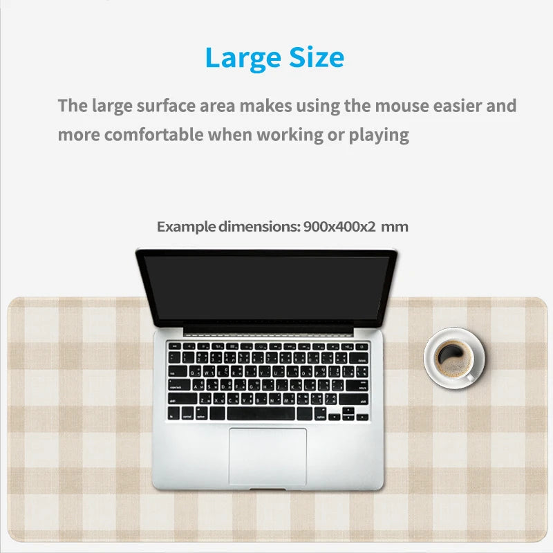 A silver laptop is placed on a beige plaid mouse pad with a coffee cup nearby.