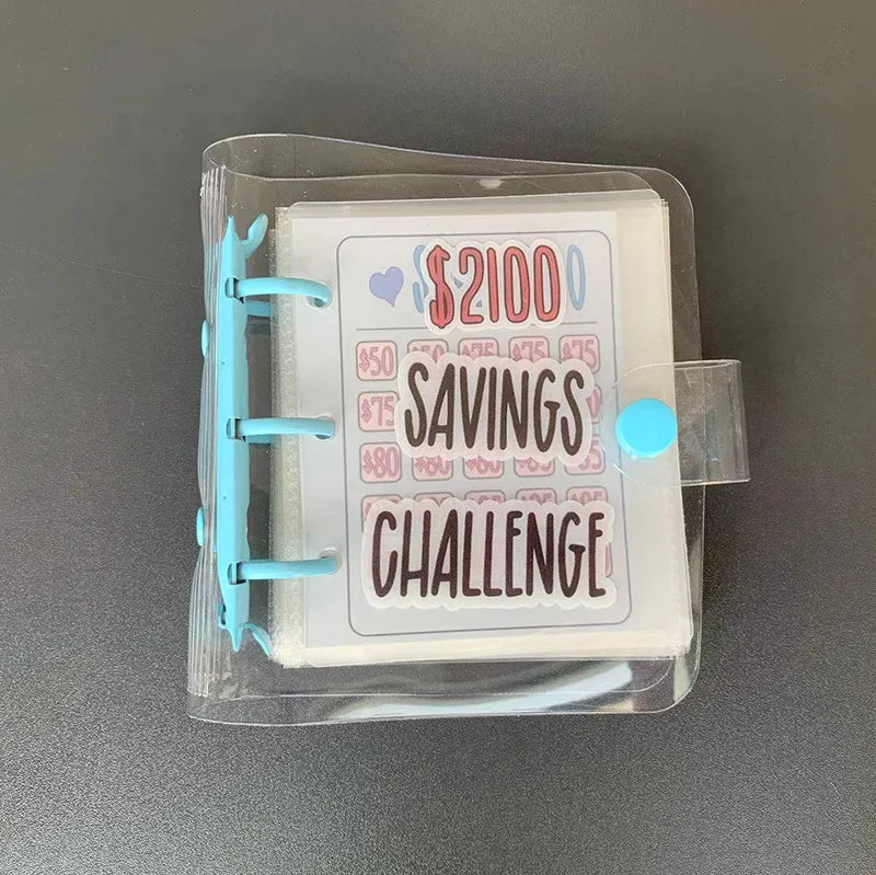 A clear plastic binder with a white sheet inside showing a $2100 savings challenge list.