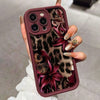 A hand holds a dark mauve leopard print phone case featuring deep purple floral designs.