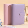 A pink and lavender A6 PU leather budget binder with cash envelopes shown in a close-up view.