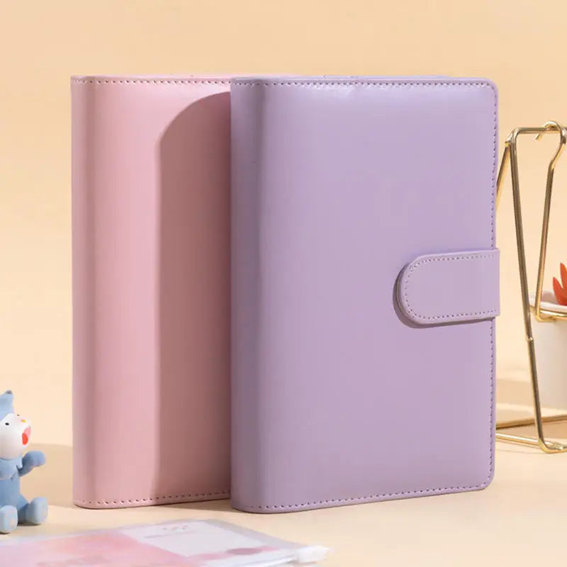 A pink and lavender A6 PU leather budget binder with cash envelopes shown in a close-up view.