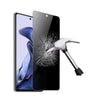 A black privacy tempered glass screen protector is shown next to a smartphone, with a silver tool in the background.