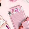 Pink wiederverwendbare Poly-Blasen-Umschläge mit Mockup-Design auf pinkem Untergrund.
