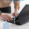 A close-up of a portable USB-C power adapter being used to charge a laptop.