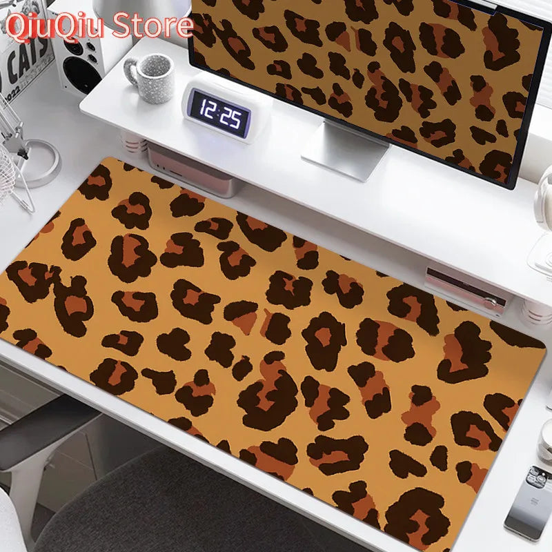 A large leopard print desk pad is displayed on a white desk next to a digital clock and other accessories.