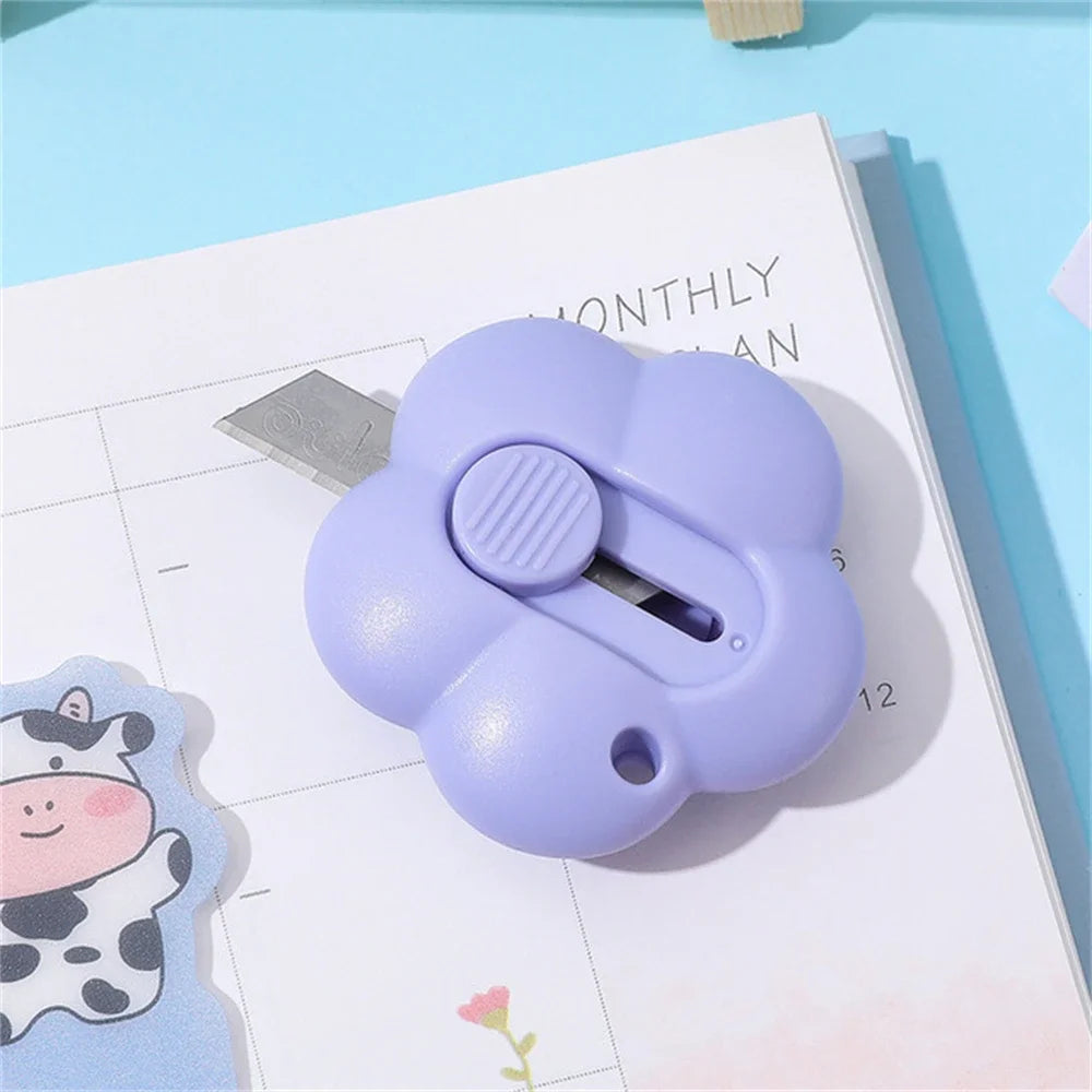 A purple floral design letter opener and paper cutter resting on a monthly planner page.