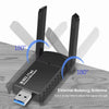 محول واي فاي USB أسود مع هوائي دوار خارجي على سطح خشبي.