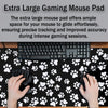 A black gaming mouse is placed on an extra large pet paw print desk mat with white paw prints.