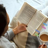 A person is reading a book with transparent self-adhesive sticky notes used for annotation.
