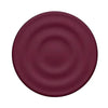 A round, deep plum colored silicone ripple grip magnetic phone stand.