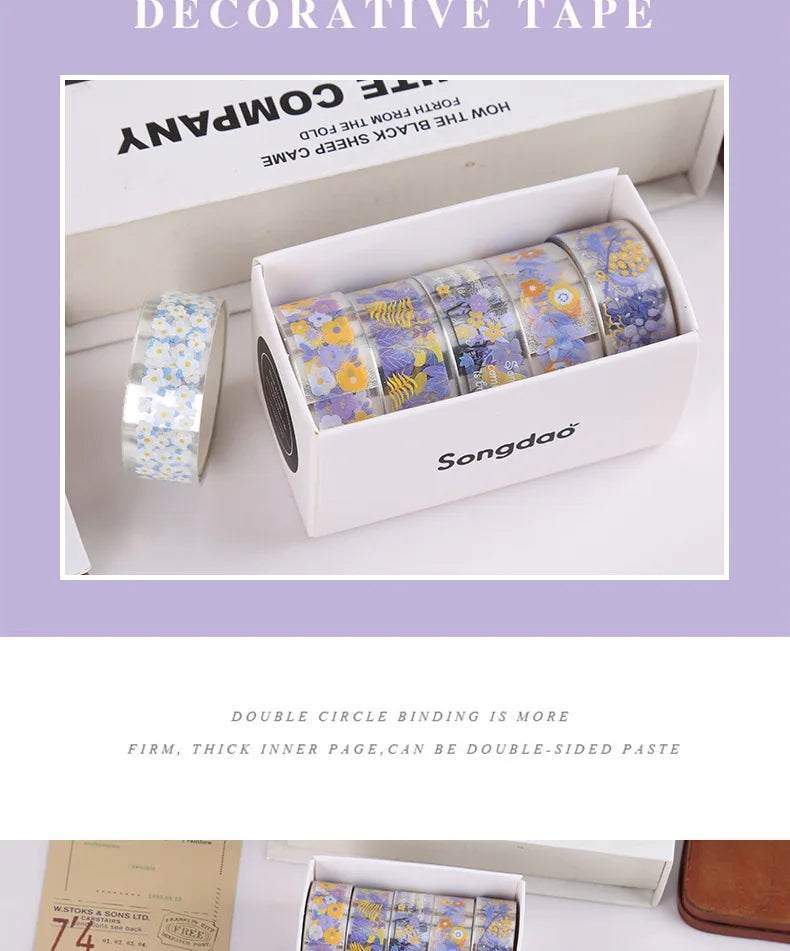 A box of decorative transparent washi tape rolls featuring purple and yellow floral patterns.