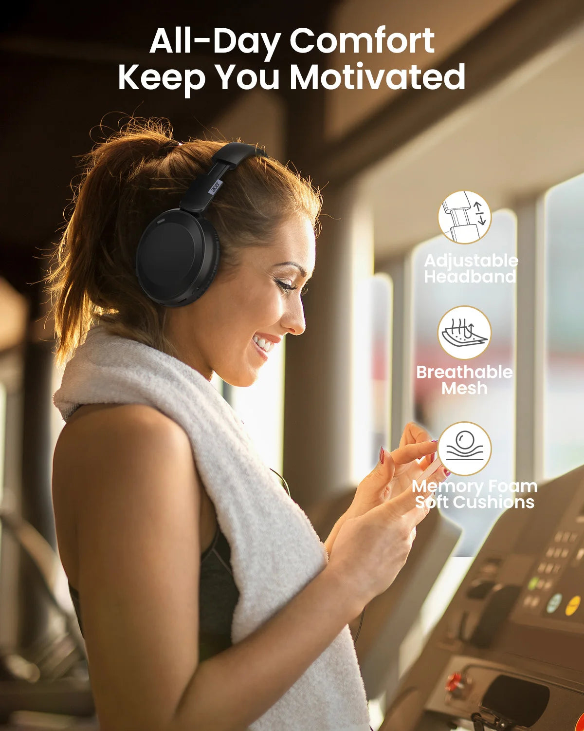 A woman wearing a gray knitted headband and headphones is smiling while using fitness equipment.
