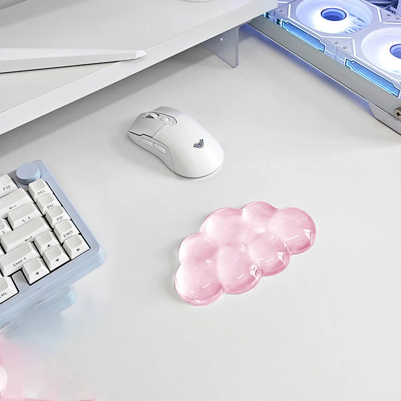 A white ergonomic cloud wrist rest is shown next to a keyboard and mouse on a white desk surface.