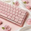 A close-up of pink crystal jelly side-printed keycaps for a mechanical keyboard resting on a soft fabric.