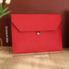 A red leather document organizer bag with a flap and silver clasp, shown on a wooden surface.