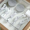 A collection of white reusable hook and loop cable ties are displayed on a clear tray.