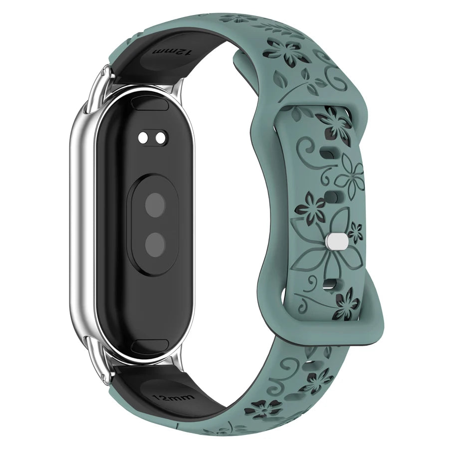 A close-up view of a teal silicone watch band with engraved flowers and a silver casing.