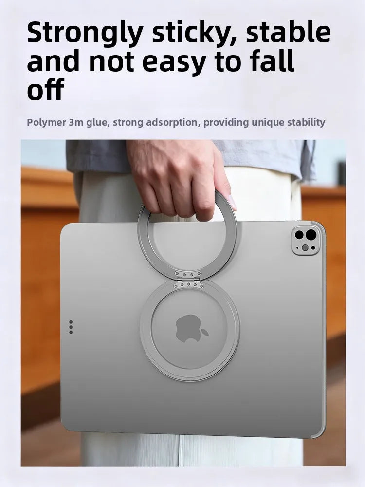 A person holds a silver magnetic tablet holder with an Apple logo on the screen, demonstrating its strong grip.