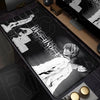 A black mouse pad featuring a monochrome illustration of a character from Death Note, displayed on a wooden desk.