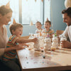 A family is having fun with bear-shaped reusable water bottles on a wooden table indoors.