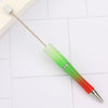 A silver pen with a green and red gradient barrel and a metal tip resting on a white surface.