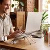 A man is using a laptop mounted on an anti-slip silicone feet and foldable design for support.