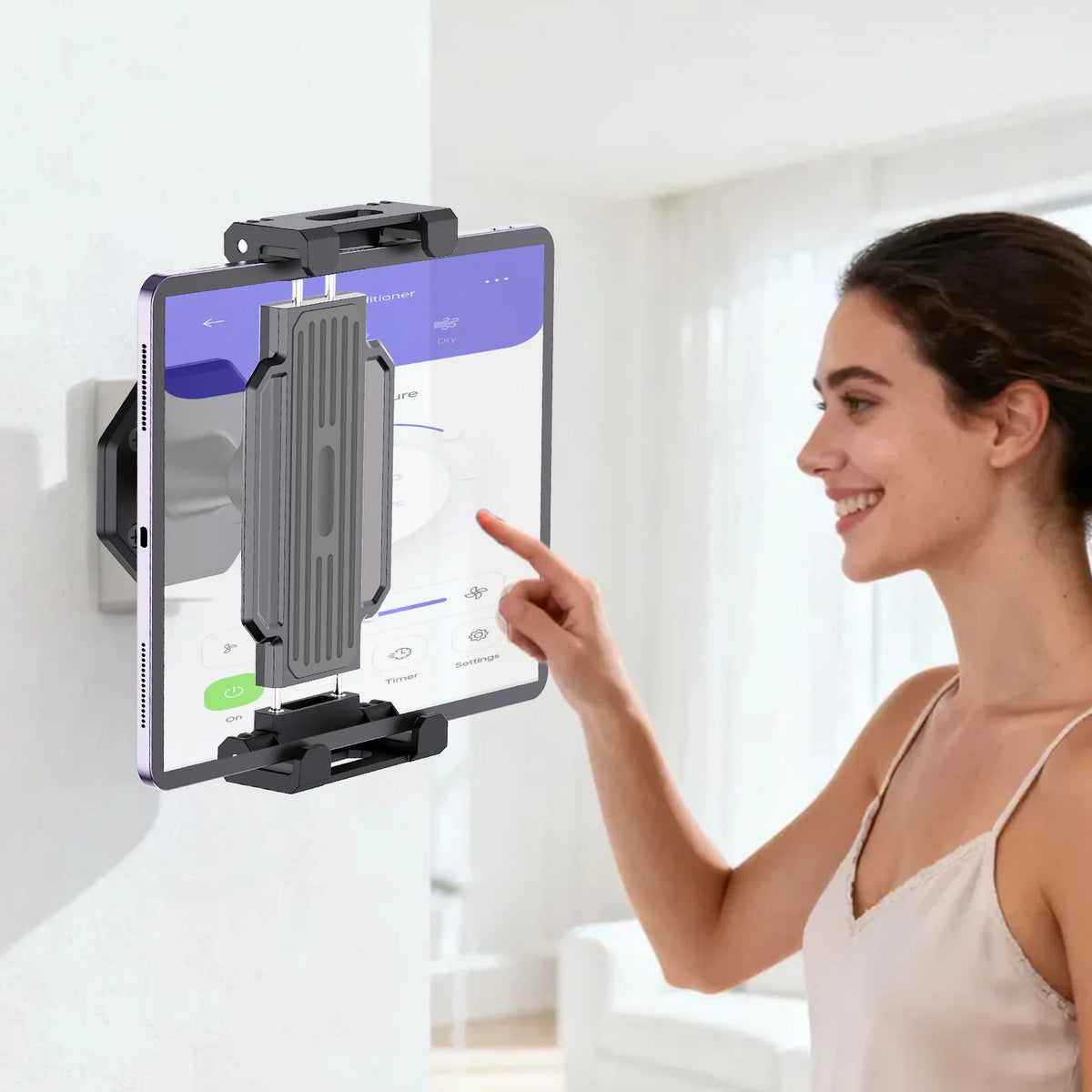 A woman is using a 360° rotating tablet wall mount stand to display content on a tablet.
