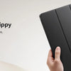 A hand holds a black magnetic folio case, demonstrating its smooth and grippy textured surface.