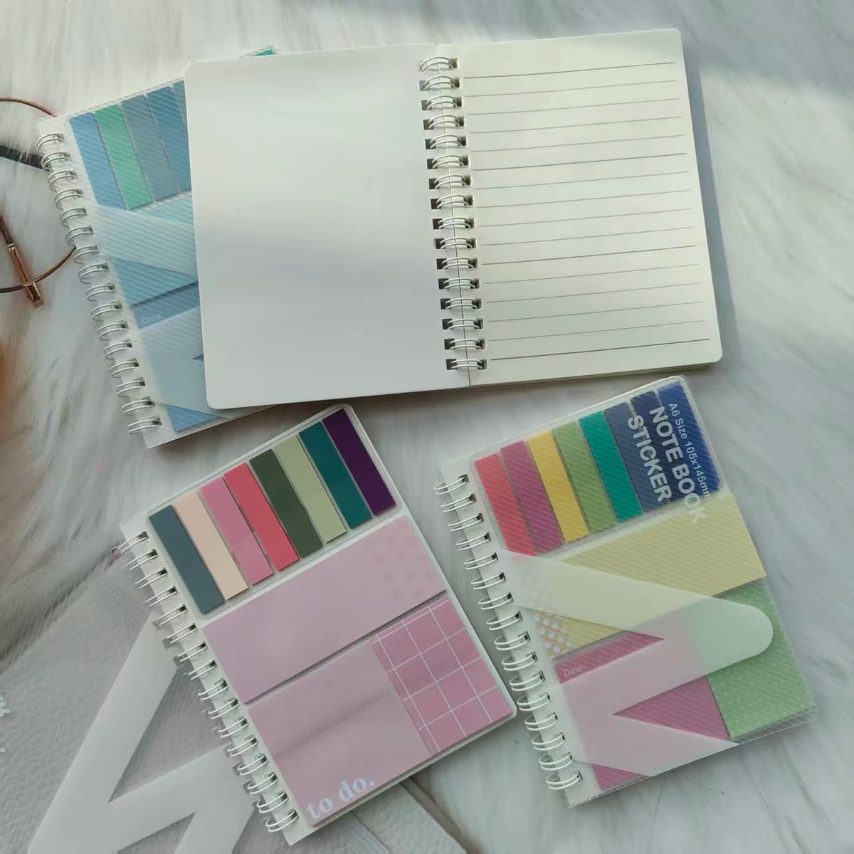 A stack of colorful A6 sticky note notebooks with loop closures and various pastel colors.