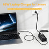 A black 65W laptop charger for Lenovo, featuring a power brick and cable, placed next to a laptop.