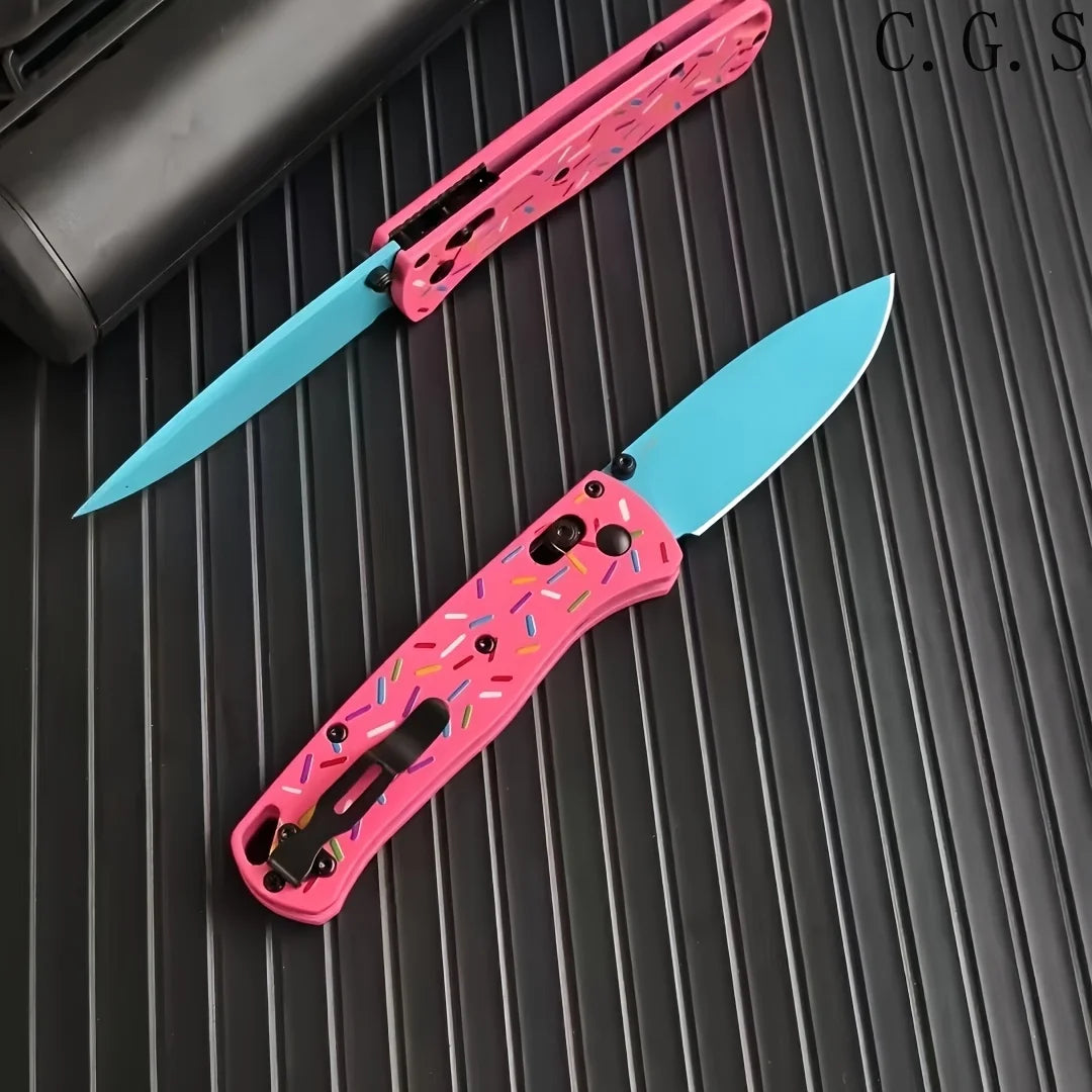 A pink acrylic folding knife with a light blue blade is shown on a dark surface.